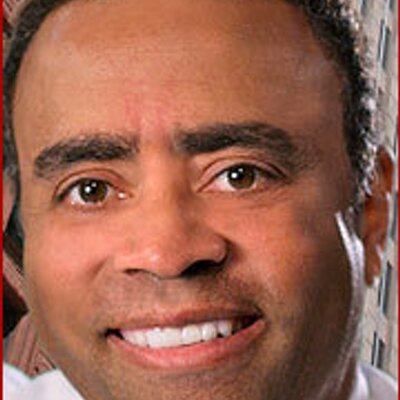 chenault_400x400webp - BroadcastingVault.com Close-up portrait of a man smiling at the camera, showing white teeth and dark hair. (informative portrait)